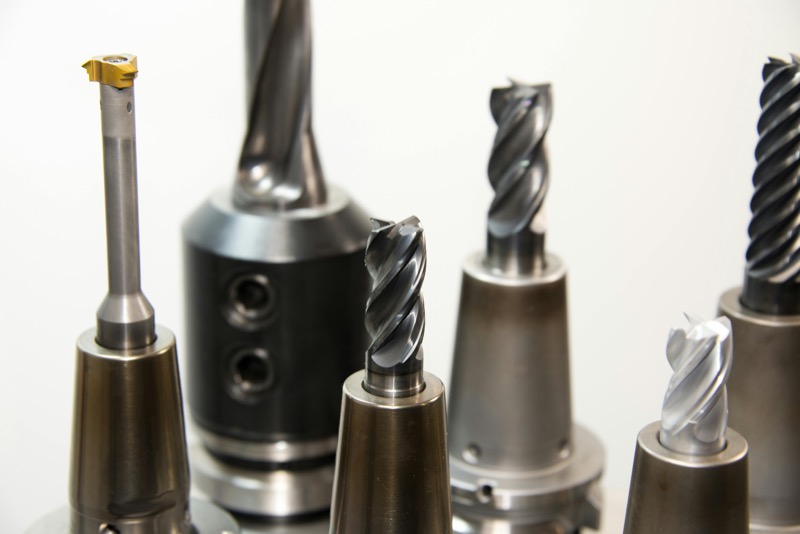 Collection of CNC cutting tools including end mills, boring bars, and carbide inserts